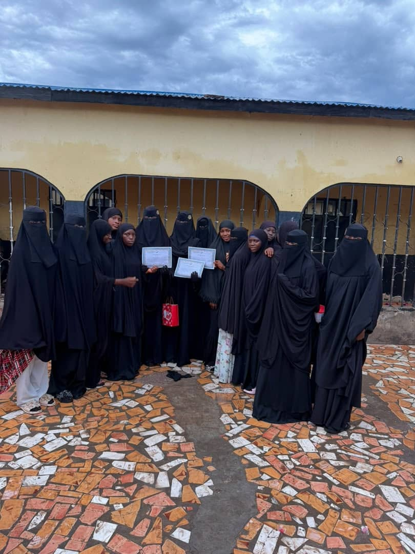 Female students holding certificates at a Daara graduation ceremony