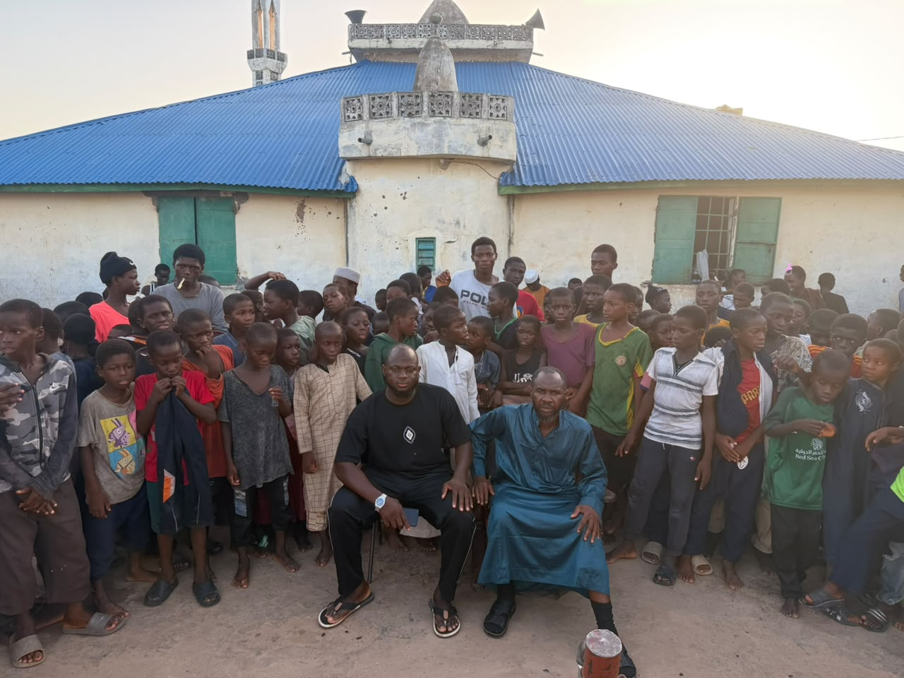 Sheikh Musa Saidy seated with students outside the Daara
