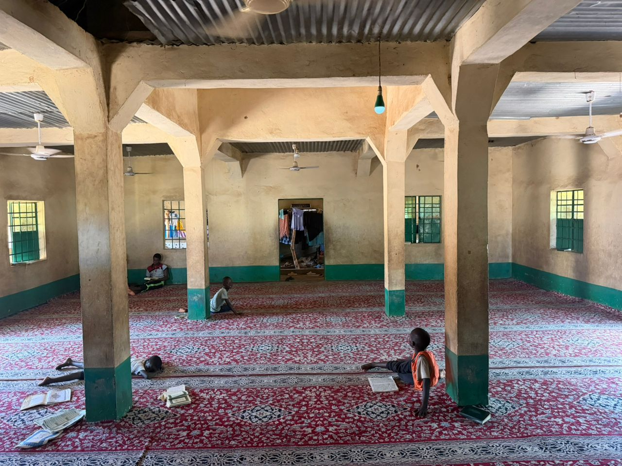 Daara students studying the Quran on the carpet inside the Daara